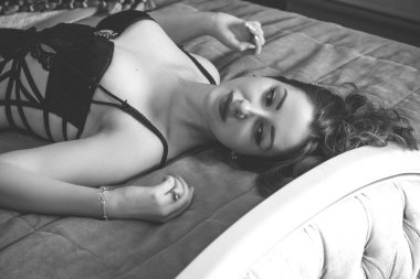 Viktorya dönemi tarzı iç mimarisi olan oldukça görkemli bir kadın yatak odasında, dantelli kısa elbise giymiş. Kadınlık ve çekicilik kavramı