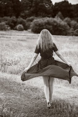 Özgürlük kavramı, uzun siyah puantiyeli zarif kadın sahada nokta elbisesi, bayanlar için klasik tarz.