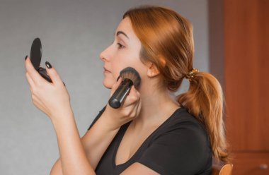 Sıradan bir kız, evde makyaj yapıyor. Telafi süreci, adım adım. Göz ve yüz makyajı.