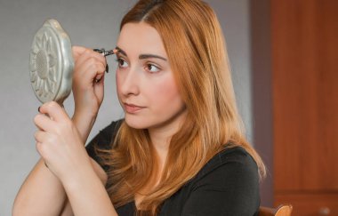 Sıradan bir kız, evde makyaj yapıyor. Telafi süreci, adım adım. Göz ve yüz makyajı.