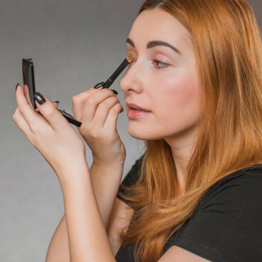 Sıradan bir kız, evde makyaj yapıyor. Telafi süreci, adım adım. Göz ve yüz makyajı.