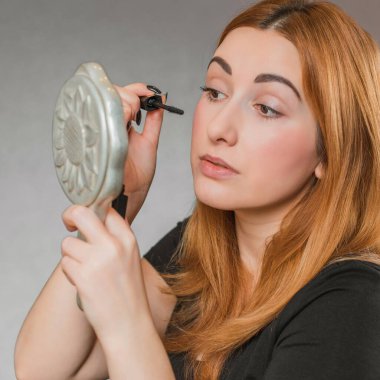 Sıradan bir kız, evde makyaj yapıyor. Telafi süreci, adım adım. Göz ve yüz makyajı.