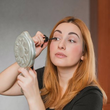 Sıradan bir kız, evde makyaj yapıyor. Telafi süreci, adım adım. Göz ve yüz makyajı.