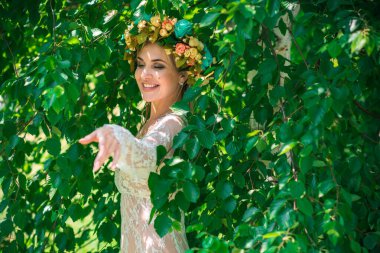 Uzun, beyaz dantelli bir elbise ve çelenk giymiş muhteşem bir göl perisi. Sanatsal fotoğrafçılık, gizemli sahne. Avrupalı cadı. Peri masalı