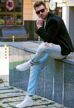 Yakışıklı genç adam eski kentte mavi kot, siyah ceket, beyaz gömlek, gözlük, şık saç, iyi ruh hali, güzel moda erkek arkadaş, vatandaş, güzel yüze sahip.