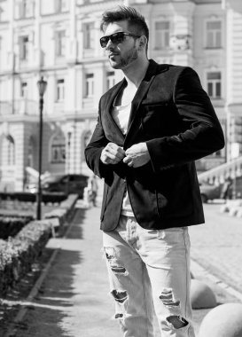 Yakışıklı genç adam eski kentte mavi kot, siyah ceket, beyaz gömlek, gözlük, şık saç, iyi ruh hali, güzel moda erkek arkadaş, vatandaş, güzel yüze sahip.