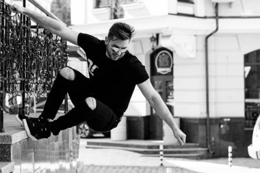 Yakışıklı genç adam eski kentte mavi kot, siyah ceket, beyaz gömlek, gözlük, şık saç, iyi ruh hali, güzel moda erkek arkadaş, vatandaş, güzel yüze sahip.