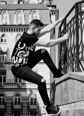 Yakışıklı genç adam eski kentte mavi kot, siyah ceket, beyaz gömlek, gözlük, şık saç, iyi ruh hali, güzel moda erkek arkadaş, vatandaş, güzel yüze sahip.