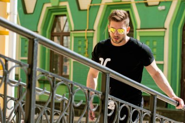 Yakışıklı genç adam eski kentte mavi kot, siyah ceket, beyaz gömlek, gözlük, şık saç, iyi ruh hali, güzel moda erkek arkadaş, vatandaş, güzel yüze sahip.