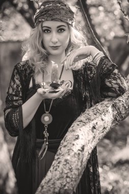 Çingene ruhu Tarot kartları, mumları ve sihirli topuyla tarlada, yaşam tarzında, öngörülerinde, Cadılar Bayramı 'nda kostüm için fikirleri olan Boho kadını.