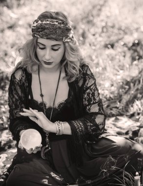 Çingene ruhu Tarot kartları, mumları ve sihirli topuyla tarlada, yaşam tarzında, öngörülerinde, Cadılar Bayramı 'nda kostüm için fikirleri olan Boho kadını.