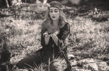 Çingene ruhu Tarot kartları, mumları ve sihirli topuyla tarlada, yaşam tarzında, öngörülerinde, Cadılar Bayramı 'nda kostüm için fikirleri olan Boho kadını.