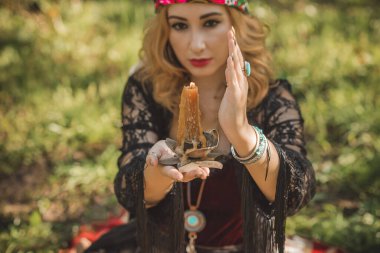 Çingene ruhu Tarot kartları, mumları ve sihirli topuyla tarlada, yaşam tarzında, öngörülerinde, Cadılar Bayramı 'nda kostüm için fikirleri olan Boho kadını.