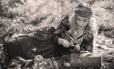 Çingene ruhu Tarot kartları, mumları ve sihirli topuyla tarlada, yaşam tarzında, öngörülerinde, Cadılar Bayramı 'nda kostüm için fikirleri olan Boho kadını.