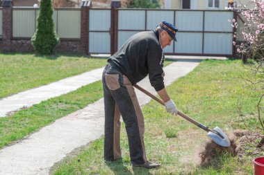 Bahar bahçesindeki adam. Bahçedeki son sınıf öğrencisi, adam hobisini seviyor, bahçede çalışıyor.