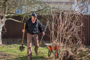 Bahar bahçesindeki adam. Bahçedeki son sınıf öğrencisi, adam hobisini seviyor, bahçede çalışıyor.