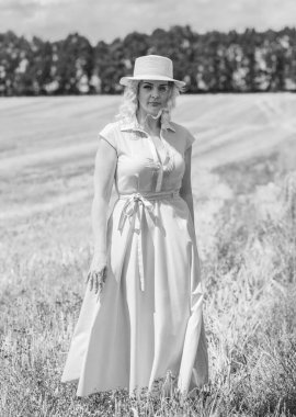 Country tarzı bir karışım, artı yumuşak pamuklu hafif elbiseli bir kadın. Samanlıktaki güzel bayanın portresi.