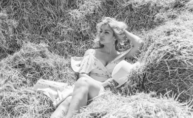 Country tarzı bir karışım, artı yumuşak pamuklu hafif elbiseli bir kadın. Samanlıktaki güzel bayanın portresi.