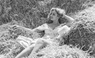 Country tarzı bir karışım, artı yumuşak pamuklu hafif elbiseli bir kadın. Samanlıktaki güzel bayanın portresi.