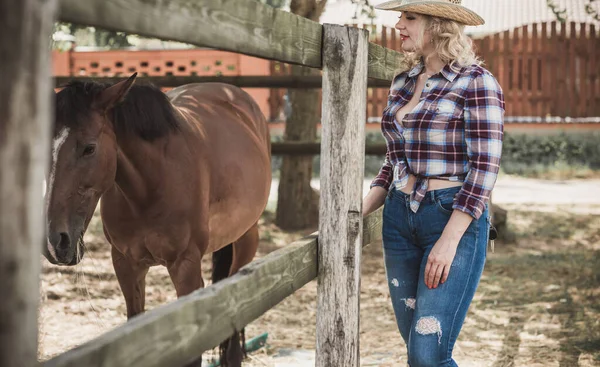美国乡村风格女人和她的马说话骑着马 穿着格子花衬衫的女人 骑着马 骑着牧草夫人的画像 — 图库照片