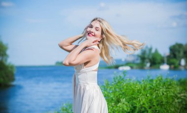 Güzel, şık elbiseli genç bir kadın plajda dinleniyor, tatil ve gezi konseptinde dinleniyor.