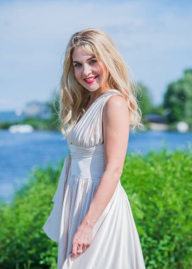 Güzel, şık elbiseli genç bir kadın plajda dinleniyor, tatil ve gezi konseptinde dinleniyor.