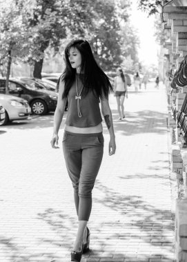 Koyu renk uzun saçlı mavi takım elbiseli bir kadın şehirde arkadaşlarını bekliyor. Büyük bir metropolün ve vatandaşların yaşam tarzı.