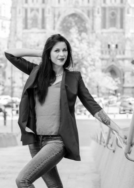 Koyu renk uzun saçlı mavi takım elbiseli bir kadın şehirde arkadaşlarını bekliyor. Büyük bir metropolün ve vatandaşların yaşam tarzı.