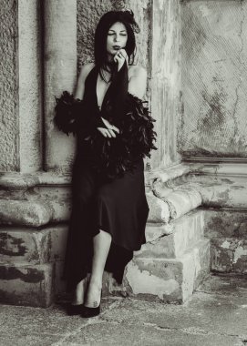 Cadılar Bayramı 'nda gotik ve görkemli retro görünümlü bir bayan. Tüyleri ve el yapımı güzel aksesuarları olan klasik elbiseli güzel bir vatandaş. Cadılar Bayramı için fikirler