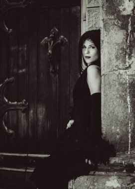 Cadılar Bayramı 'nda gotik ve görkemli retro görünümlü bir bayan. Tüyleri ve el yapımı güzel aksesuarları olan klasik elbiseli güzel bir vatandaş. Cadılar Bayramı için fikirler