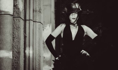 Cadılar Bayramı 'nda gotik ve görkemli retro görünümlü bir bayan. Tüyleri ve el yapımı güzel aksesuarları olan klasik elbiseli güzel bir vatandaş. Cadılar Bayramı için fikirler