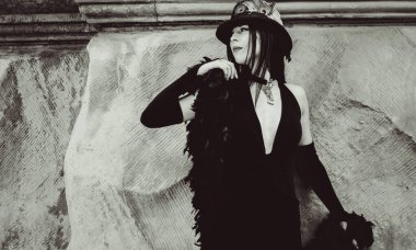 Cadılar Bayramı 'nda gotik ve görkemli retro görünümlü bir bayan. Tüyleri ve el yapımı güzel aksesuarları olan klasik elbiseli güzel bir vatandaş. Cadılar Bayramı için fikirler