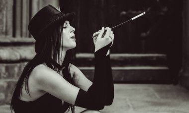 Cadılar Bayramı 'nda gotik ve görkemli retro görünümlü bir bayan. Tüyleri ve el yapımı güzel aksesuarları olan klasik elbiseli güzel bir vatandaş. Cadılar Bayramı için fikirler