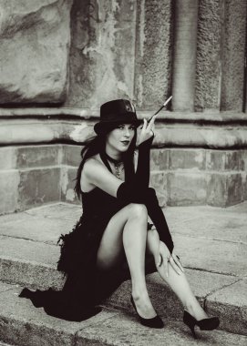 Cadılar Bayramı 'nda gotik ve görkemli retro görünümlü bir bayan. Tüyleri ve el yapımı güzel aksesuarları olan klasik elbiseli güzel bir vatandaş. Cadılar Bayramı için fikirler