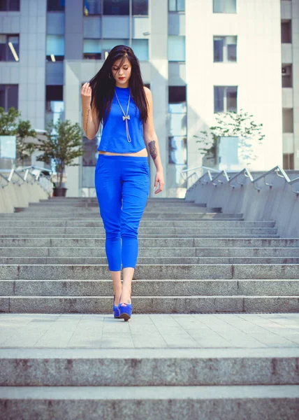 Een Vrouw Een Blauw Pak Met Donker Lang Haar Wacht — Stockfoto