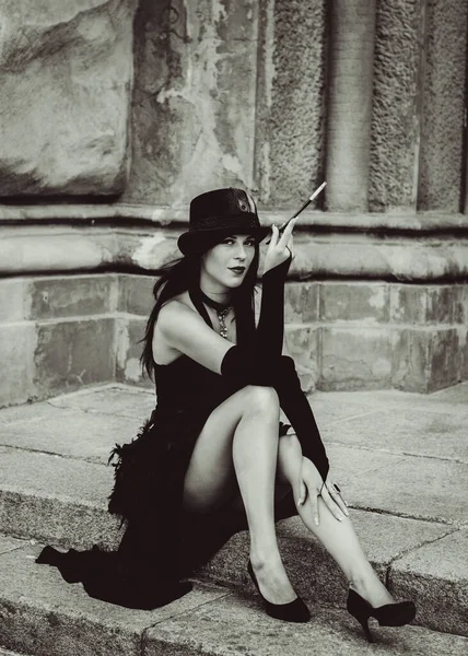 Cadılar Bayramı 'nda gotik ve görkemli retro görünümlü bir bayan. Tüyleri ve el yapımı güzel aksesuarları olan klasik elbiseli güzel bir vatandaş. Cadılar Bayramı için fikirler