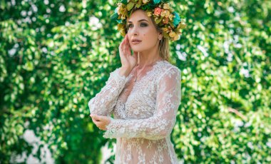Çiçek çemberli, saçlı, dantelli, gölde şeffaf elbiseli romantik bir kadın.