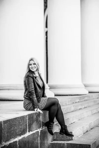 Happy woman of plus size, American or European appearance enjoying life. Young lady with excess weight, stylishly dressed at city street. Natural beauty