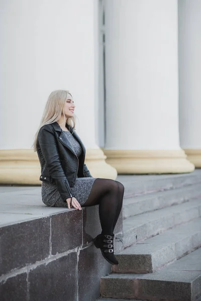 Happy woman of plus size, American or European appearance enjoying life. Young lady with excess weight, stylishly dressed at city street. Natural beauty