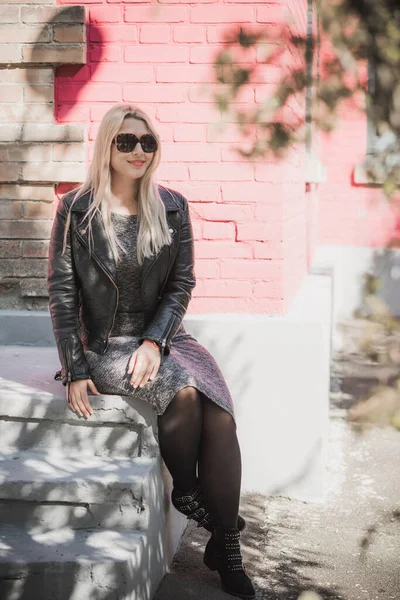 Happy woman of plus size, American or European appearance enjoying life. Young lady with excess weight, stylishly dressed at city street. Natural beauty