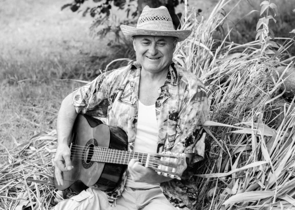 面白いです年上の男でプリントシャツ観光ギターを演奏し 自然の中で歌を歌います屋外で アメリカへの旅行と休暇のための喜び — ストック写真