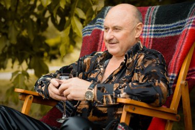 Olgun stil sahibi bir adam sonbaharda geleneksel kırmızı ekose şarabını tadıyor. Yalnız yaşlılar bir kadeh kırmızı şarap içiyorlar. Hayatı ve şarapla ilgili sorunları düşünüyorum.