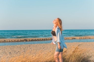 Deniz kenarında dinlenen dolgun kalçalı Avrupalı kadın mayo giydiğini gösterdi. 