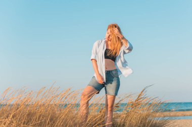 Deniz kenarında dinlenen dolgun kalçalı Avrupalı kadın mayo giydiğini gösterdi. 