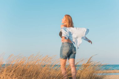 Deniz kenarında dinlenen dolgun kalçalı Avrupalı kadın mayo giydiğini gösterdi. 