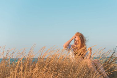 Deniz kenarında dinlenen dolgun kalçalı Avrupalı kadın mayo giydiğini gösterdi. 