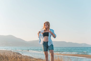 Deniz kenarında dinlenen dolgun kalçalı Avrupalı kadın mayo giydiğini gösterdi. 