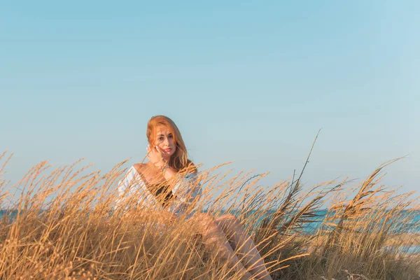 Deniz kenarında dinlenen dolgun kalçalı Avrupalı kadın mayo giydiğini gösterdi. 