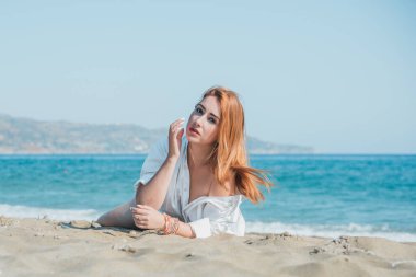 Deniz kenarında dinlenen dolgun kalçalı Avrupalı kadın mayo giydiğini gösterdi. 