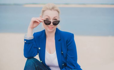 Modern iş kadınının portresi her hafta plajda dinleniyor. 